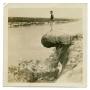 Photograph: [Photograph of Soldier Standing on Rock]