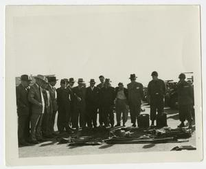 [Photograph of Civilians and Military Personnel Standing Around a Tarp with Tools]