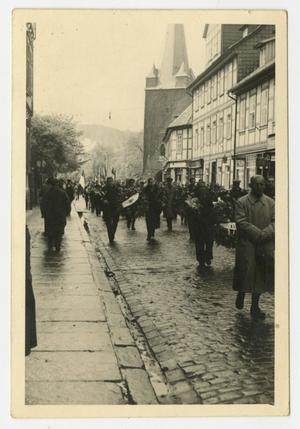 [Photograph of a Group of People Walking Down a Street]