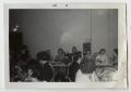 Photograph: [Photograph of Men and Women Sitting at Tables]