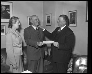 Man receiving check from man and woman (March of Dimes)