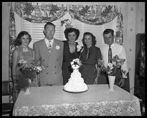 Mrs. A. H. Roberts standing with group behind cake