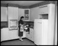 Primary view of [Woman Using Mixer in Kitchen]