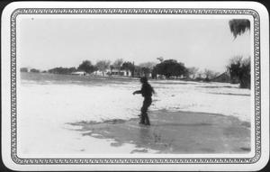 [Photograph of Mary Jones sliding across an iced water puddle in the pasture]