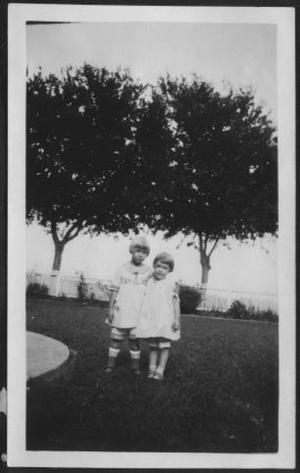 Primary view of object titled '[Photograph of Mary Jones and another young girl in the front yard of the George Ranch house]'.