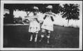 Primary view of [Photograph of Mary Jones and another young girl eating watermelon]