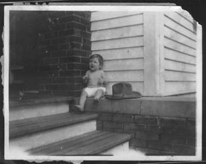 [Photograph of Mary Jones sitting on the front porch of the George Ranch house]