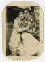 Photograph: [Photograph of Two Woman Hugging by an Automobile]