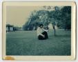 Photograph: [Photograph of a Young Man Kneeling in the Grass]