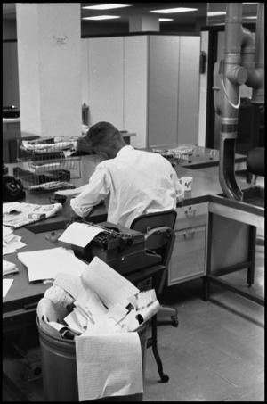 Primary view of object titled '[Man Working at Desk at Beaumont Enterprise #2]'.