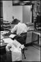 Photograph: [Man Working at Desk at Beaumont Enterprise #2]