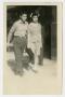 Photograph: [Photograph of Young Man and Woman Walking on Sidewalk]