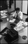 Photograph: [Man Working at Desk at Beaumont Enterprise #19]