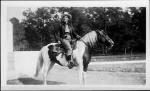 [Photograph of a woman on a paint horse]