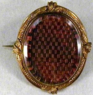 [An oval pin with a purple design]