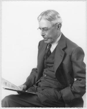 [Albert Peyton George sitting and reading a newspaper]