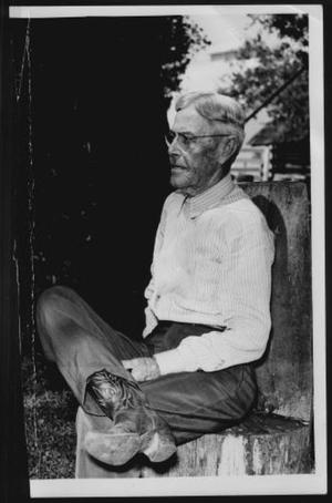 [Albert Peyton George seated on a chair in the George Ranch yard]