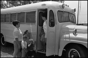 [Women and Children Standing Close to School Bus Turned Mobile Home]