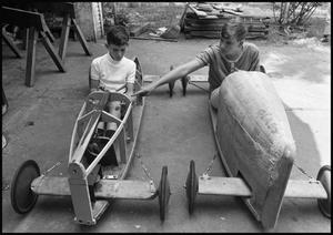 [Boys Sitting in Their Partially Built Soap Box Derby Cars]