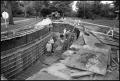 Photograph: [Road workers standing in Harrison drainage ditch]