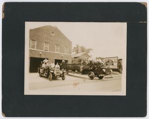 [Firefighters and Small Boy on Two Fire Engines]
