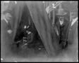 Primary view of [Albert Peyton George and two other men outside of a tent, a woman sitting in the tent]