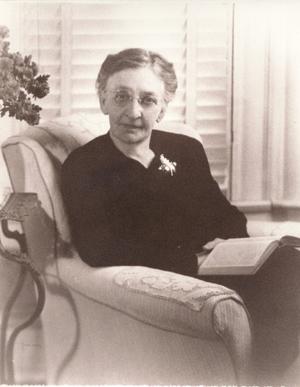 [Mamie Davis George sitting in a chair with a book in her lap]