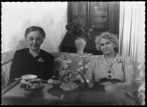 [Photograph of Mamie Davis George seated on a sofa with an unidentified woman]