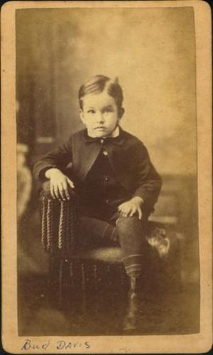 [Bud Davis as a boy, sitting with his right leg tucked under his left leg]