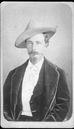 [Albert Lamar George, seated and wearing a dark three piece suit and a hat]