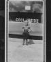 Photograph: [Patricia Shoemaker Stands in front of Sid's Cafe]