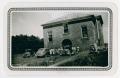 Photograph: [Photograph of People with Automobiles Outside Brick Building]