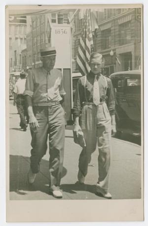 Primary view of object titled '[Photograph of Two Men Walking on Elm Street Sidewalk]'.