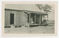 Photograph: [Woman and a Child Stand Outside Their House]