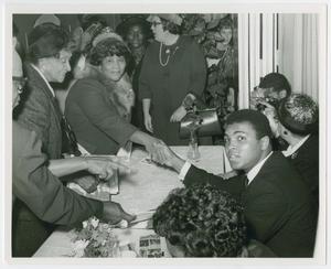 Primary view of object titled '[Muhammed Ali Shakes Hands with a Woman]'.
