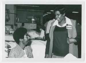 Primary view of object titled '[Barbara Jordan Speaks with a Patient at the Houston Veterans Administration Hospital]'.