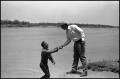 Photograph: [Photograph of a Man Helping Other Out of Lake]