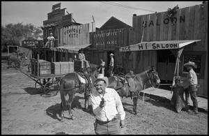 [Movie Scene of Old Western Town With Horses and Cowboys]