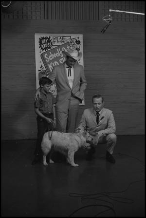 Primary view of object titled '[Two Men, Young Boy, and  Dog on Television Stage]'.
