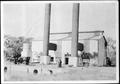 Photograph: [Factory with two large smokestacks in front of the building]