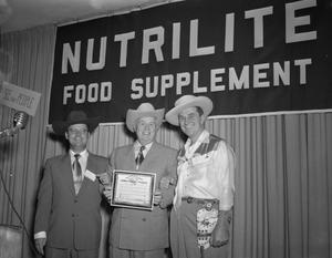 Primary view of object titled '[Three Men at the Nutrilite Food Supplement Convention]'.