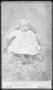 Photograph: [An unidentified baby boy sitting on a printed blanket]