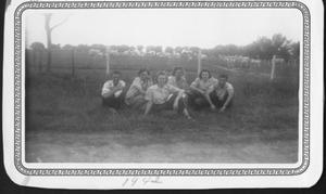 [Four young women and two men sitting in the grass at George Ranch]