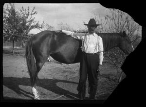 [Photograph of Man with Hand on Horse]