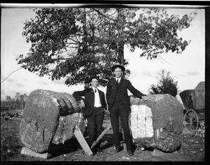 [Photograph of Two Men in Suits with Cotton Bales]