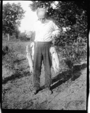 [Photograph of Elderly Man Holding Fish]