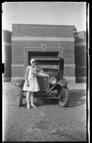[Photograph of Young Woman Standing with Automobile]