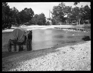 [Photograph of Covered Wagon Crossing Creek]
