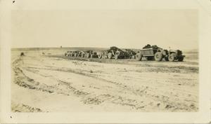 Primary view of object titled '[Line of Tractors Pulling Trailers Full of Dirt]'.
