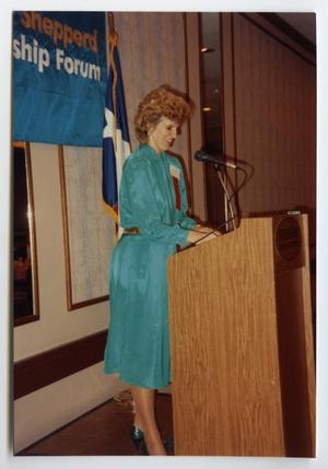 Primary view of object titled '[Photograph of Tracey Bright Behind Podium]'.